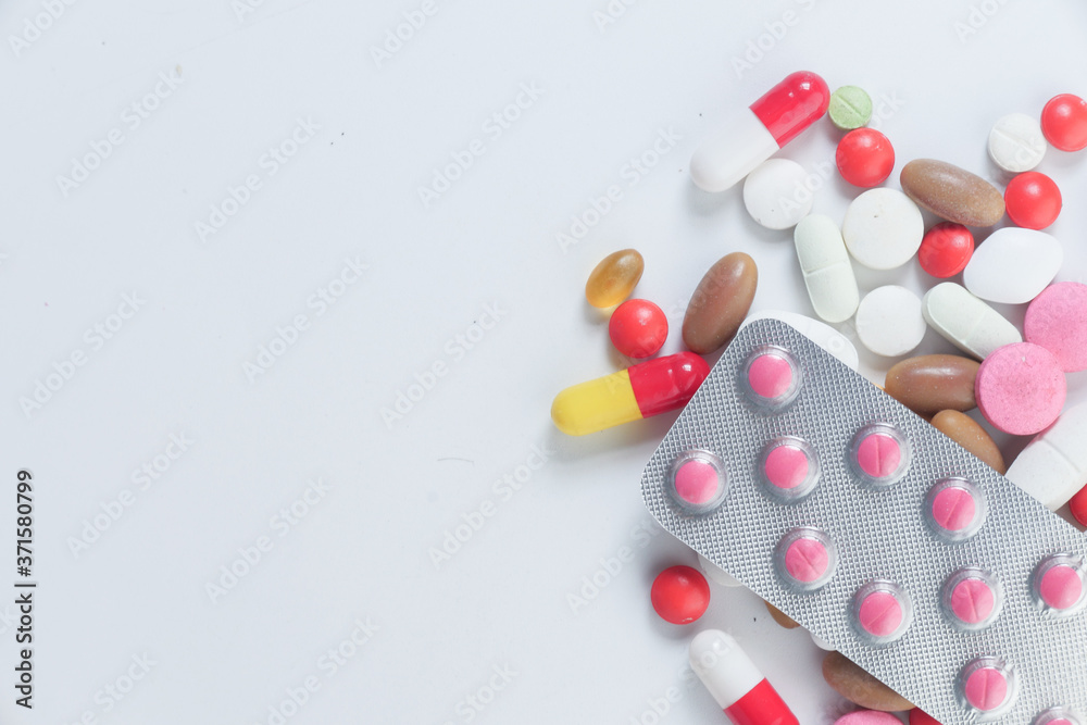 close up of colorful pills spilling from container 
