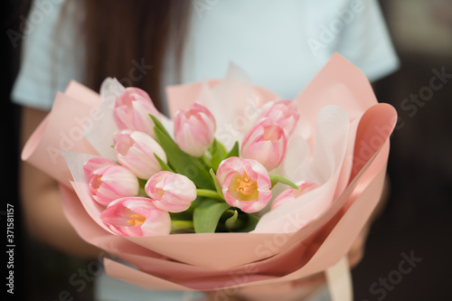 Woman holding pink tulip flower bouquet using as background wedding flower shop
