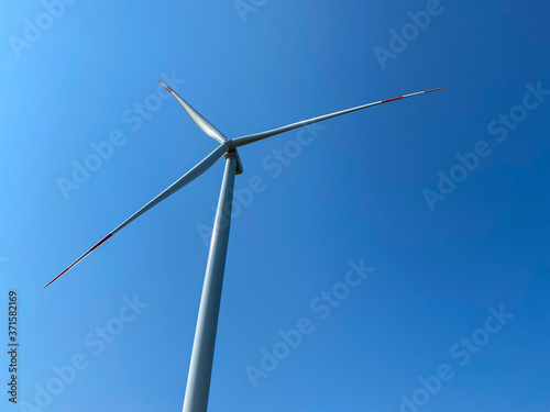Detail of a wind turbine with a blue sky, wind turbine generating electricity on blue sky, Sustainable development, renewable energy and Wind turbines generating electricity
