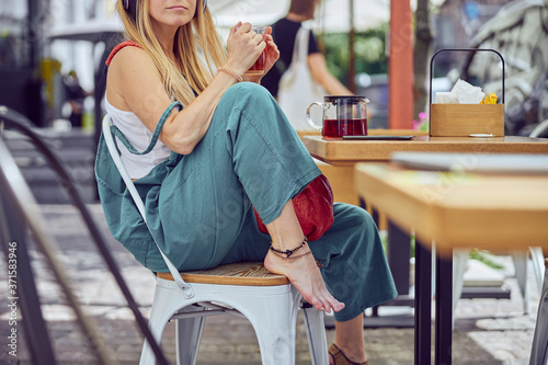 Фотография ?ropped photo of beautiful red-haired girl holding a cup of tea outdoors