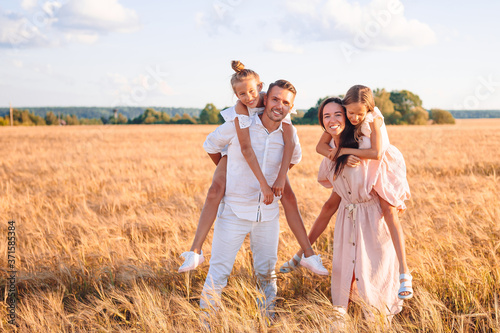 Happy family playing in a wheat field