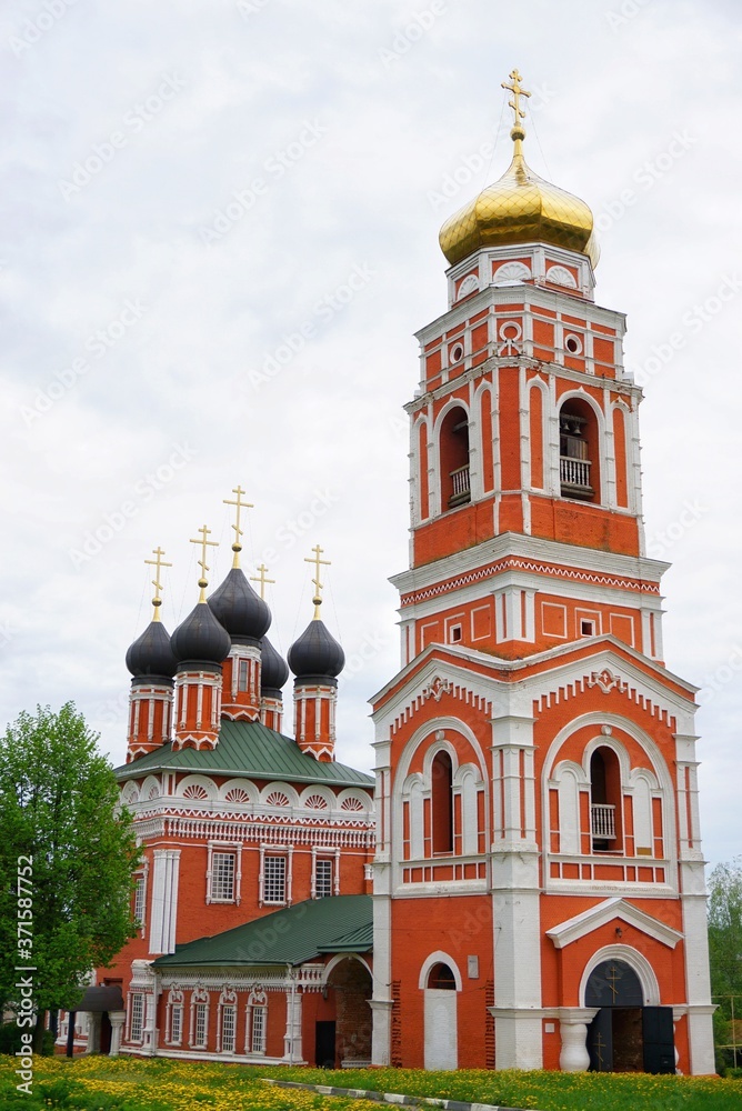Fototapeta premium red and white orthodox church on a cloudy summer day