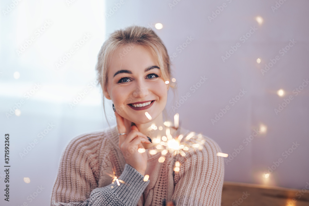 Young girl holding a sparkler in her hands is very happy about the arrival of Christmas, Merry Christmas and Happy New Year.
