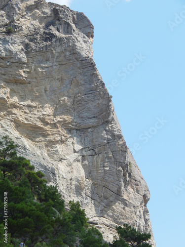 elongated, large rock and sunny sky