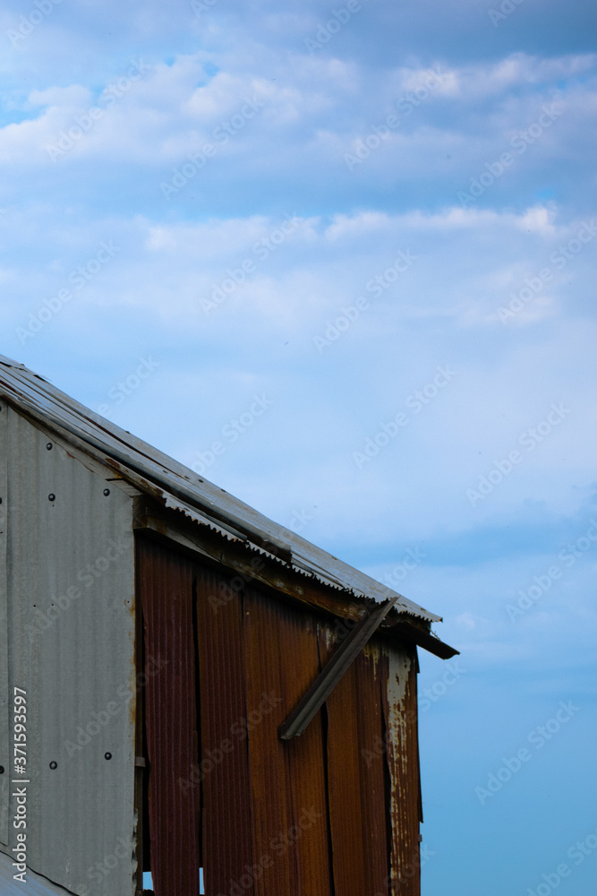 Corrugated iron farm building with red roof