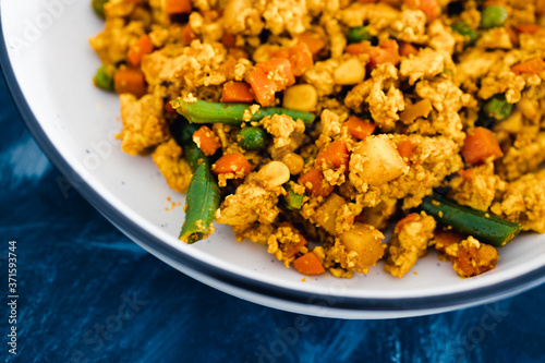 plant-based food, vegan tofu scramble with mixed vegetables including carrots green beans and peas