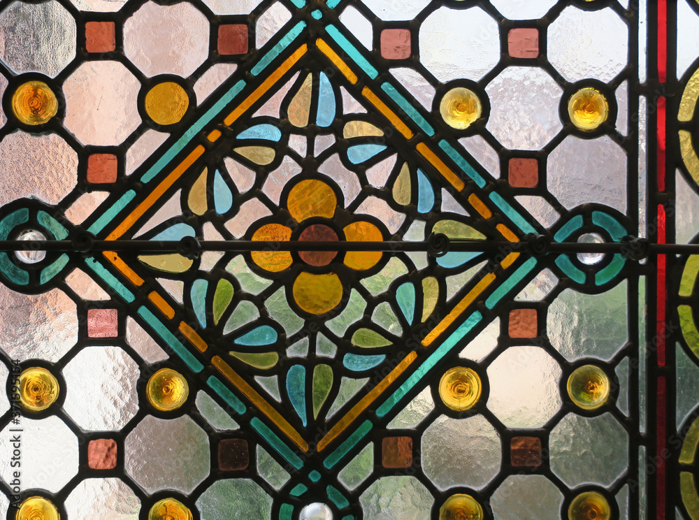 multicolored stained glass window with a flower pattern in a square