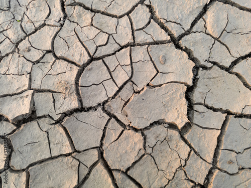 Arid and barren land caused with hot weather and drought, erosion and crack ground, abstract mosaic pattern