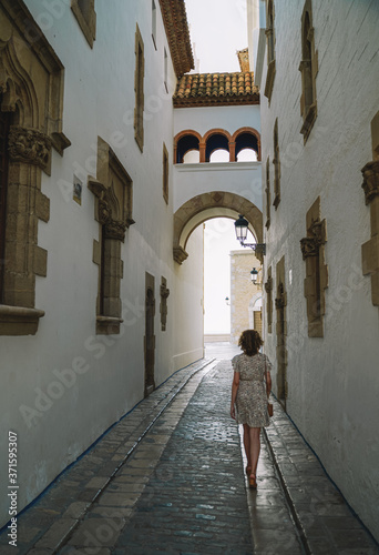 Beautiful curly brunette tourist in the Mediterranean village of Sitges © tanaonte