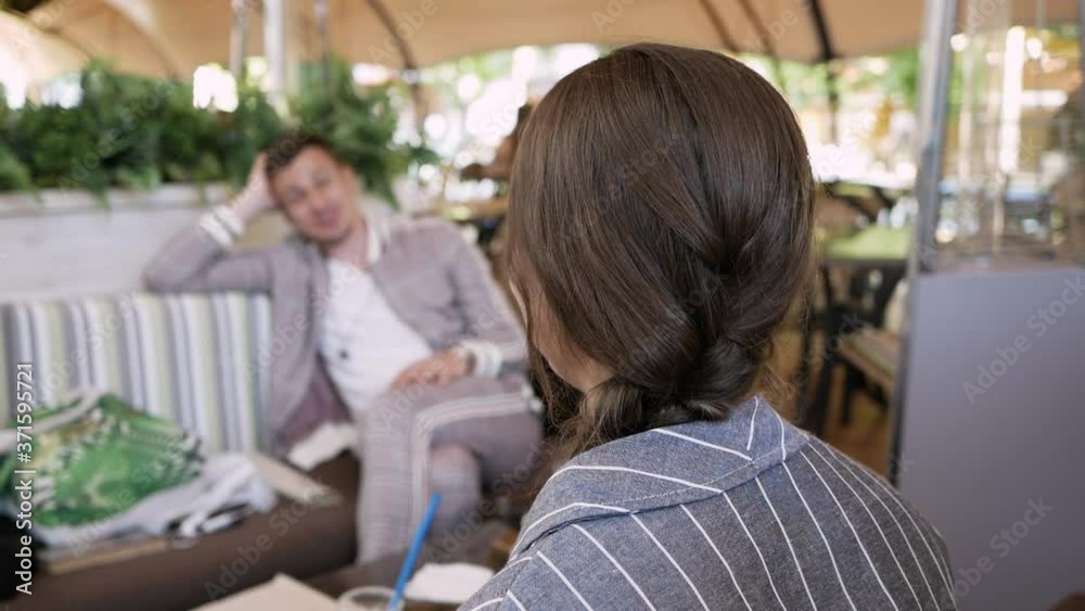 business conversation. young woman talking with man in cafe and gestures business conversation. young woman talking with man in cafe and gestures