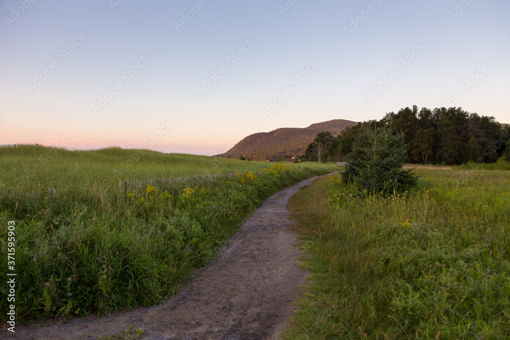 West view of deserted path along the Baie-St-Paul beach seen during a summer sunrise, Charlevoix region, Quebec, Canada 