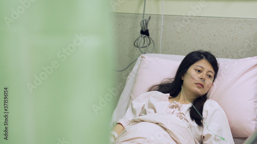 Canvas-taulu view behind hospital curtain asian woman with brain severely damaged is lying on bed