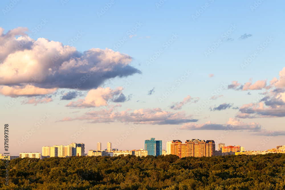 sunset blue and pink sky with and gray clouds over city and green forest in sunny summer evening sunset blue and pink sky with and gray clouds over city and green forest in sunny summer evening
