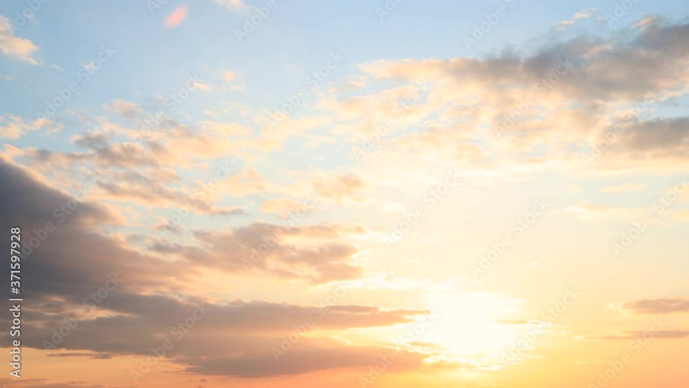 Sun Sunshine Through Sunset Sky. Bright Dramatic Sky With Fluffy Clouds. Yellow, Orange, Blue And Magenta Colours. Dawn Sky Sun Sunshine Through Sunset Sky. Bright Dramatic Sky With Fluffy Clouds. Yellow, Orange, Blue And Magenta Colours. Dawn Sky