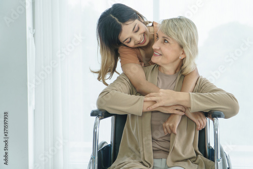 Fotografie Grandma hugs granddaughter and smiling happily