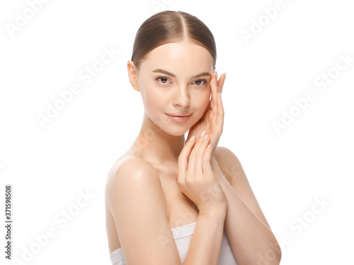 Portrait of young beautiful brown-eyed woman with naked skin and shoulders, touching cheek, isolated on white background. Female natural beauty concept