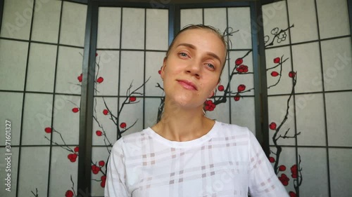 Woman touches her nose, dreaming about new shape of nose, facial plastic surgery. Pretty beautiful girl smiles and runs her hands over young face, nude makeup. Soft touch, care for beauty and health