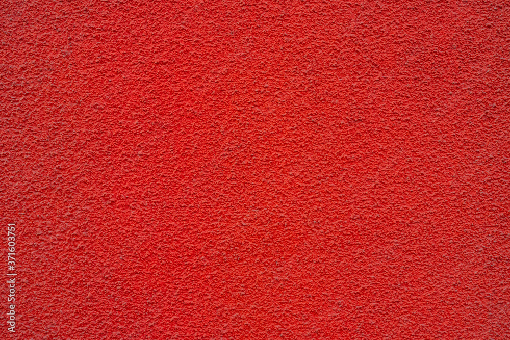 Fototapeta premium Red wall of the building. Rough plaster surface. Abstract background.