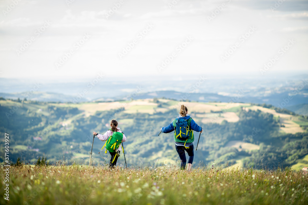 Young single mother hiking together with her daughter