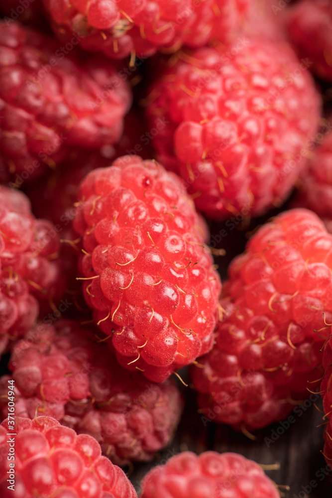 Ripe and juicy raspberry on the dark rustic background. Selective focus. Shallow depth of field. Ripe and juicy raspberry on the dark rustic background. Selective focus. Shallow depth of field.