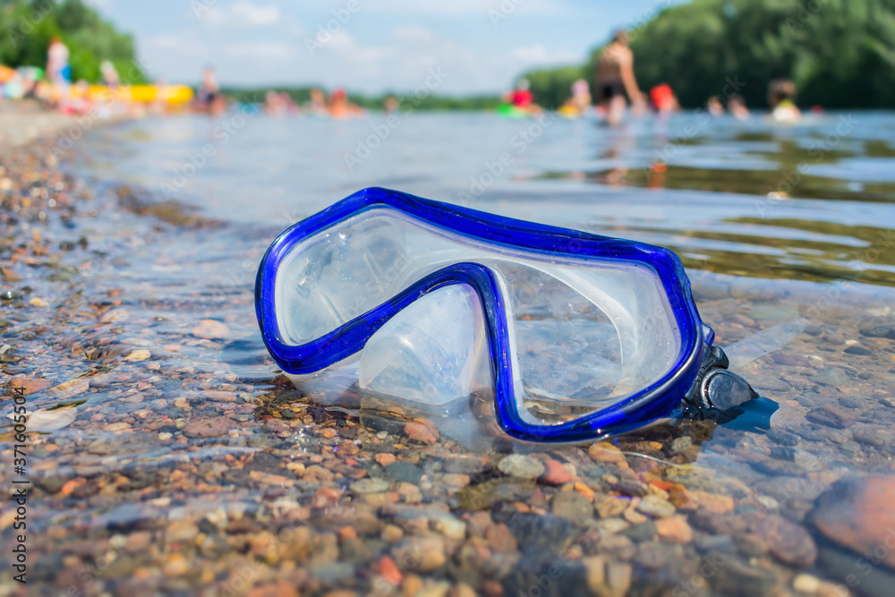 A swimming mask lost by someone lies in the water