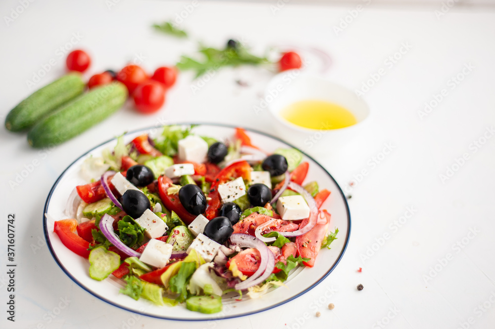 Greek vegetable salad with feta cheese and ingredients from which it is cooked on a white concrete background. Copy space.