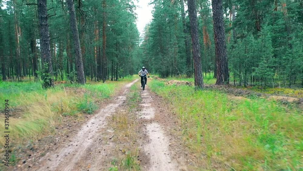 Front view of cyclist crossing the forest on high speed Front view of cyclist crossing the forest on high speed