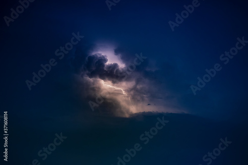 Dramatic view of heat lightning storm, thunderbolts and dramatic clouds at night time