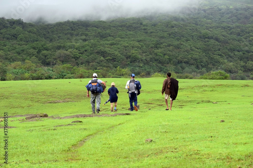 A small group of trekkers on exploration travel in Sahyadri ranges. Monsoon is the best period for trekkers to enjoy nature. Locals help in guiding tourists for jungle routes. © Rajkumar
