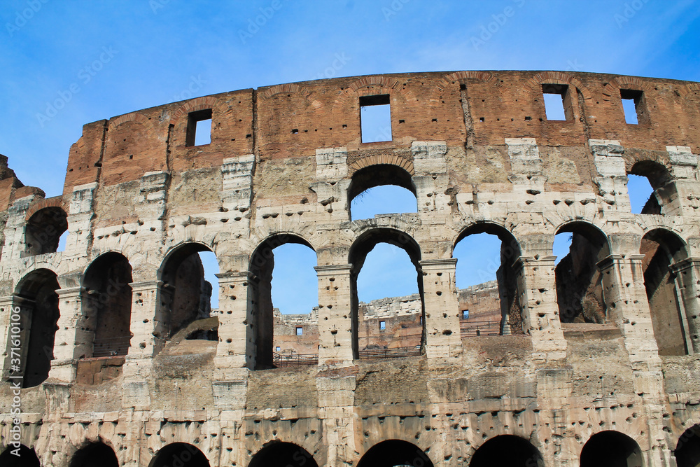 Part of Colosseum against a blue sky, rome