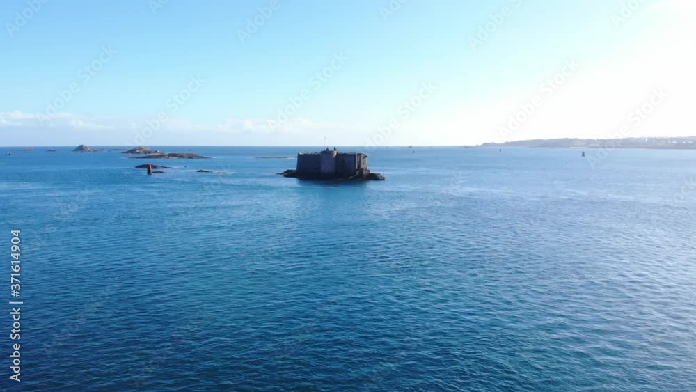 cinematic aerial drone shot from Tahiti beach ; magnificent view of Louët island and its lighthouse, as well as the castle on Taureau Island, a 16th-century fortress that used to protect the land cinematic aerial drone shot from Tahiti beach ; magnificent view of Louët island and its lighthouse, as well as the castle on Taureau Island, a 16th-century fortress that used to protect the land