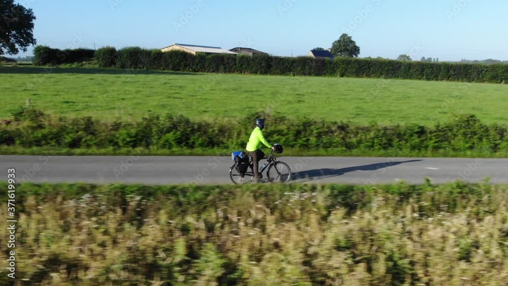 beautiful aerial view of unrecognizable man on tour bike with fluorescent biking clothes during cold morning beautiful aerial view of unrecognizable man on tour bike with fluorescent biking clothes during cold morning