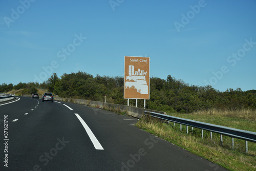 En roulant : panneau touristique sur l'autoroute A20 dans le Lot, Saint-Céré, Occitanie, France.