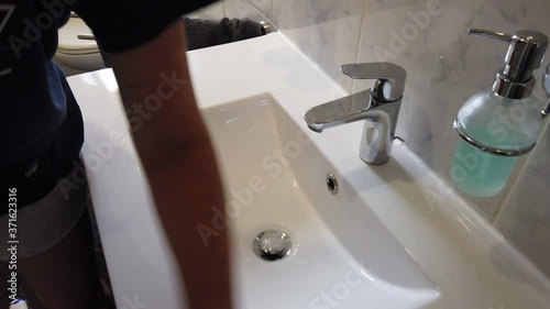 Hand mit Gummihandschuhen reinigt Bad Waschbecken Toilette WC