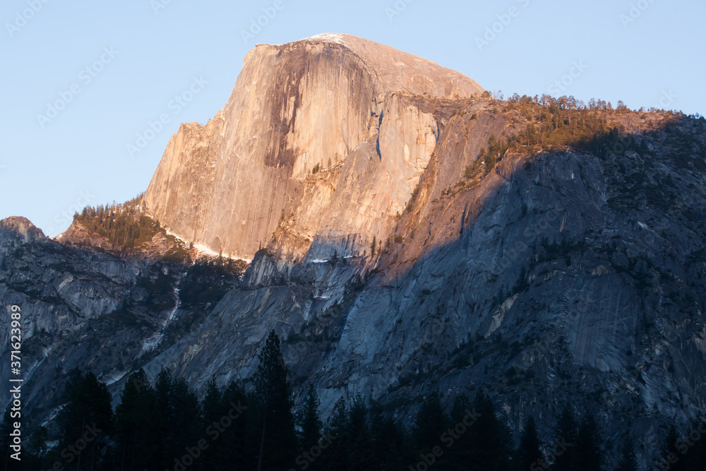 Half Dome with snow in the warm sunset light 