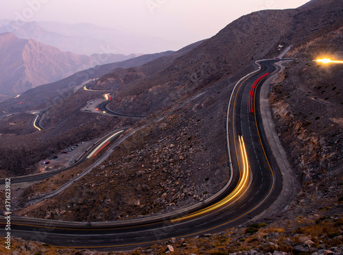 View from Jebael Jais mountain of Ras Al Khaimah emirate in the evening. United Arab Emirates, Light trails from the car