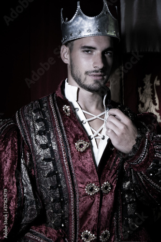Canvas Print Portrait of handsome king with beard dressed in costume, wearing a crown and loo