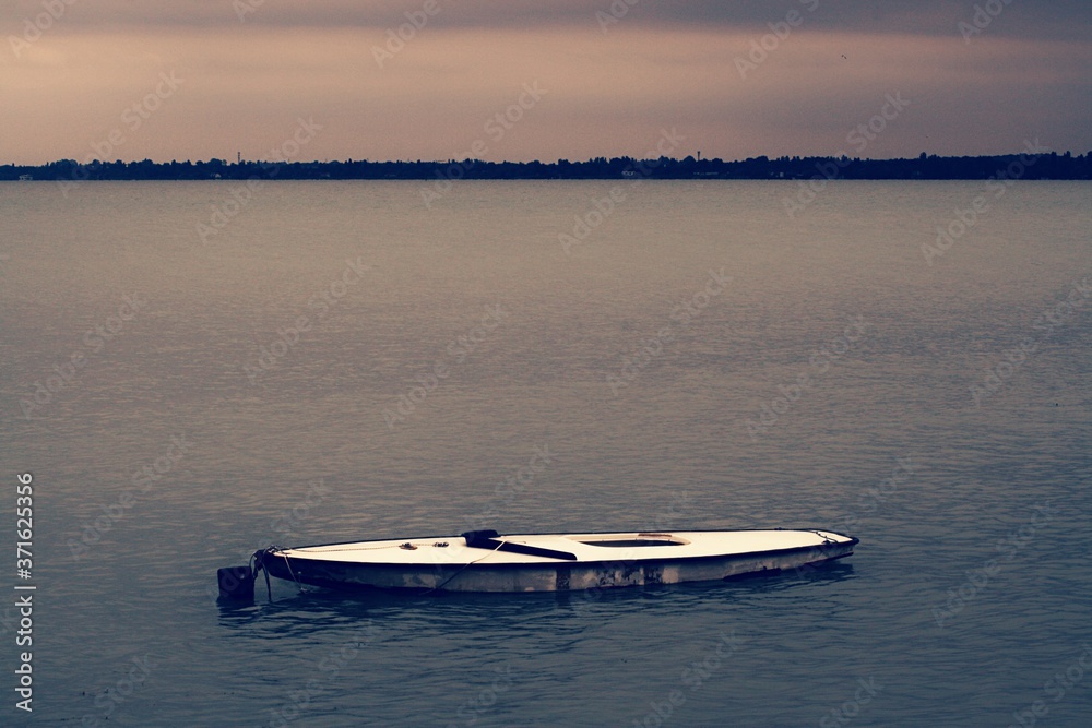 Obraz premium A small boat in a large body of water