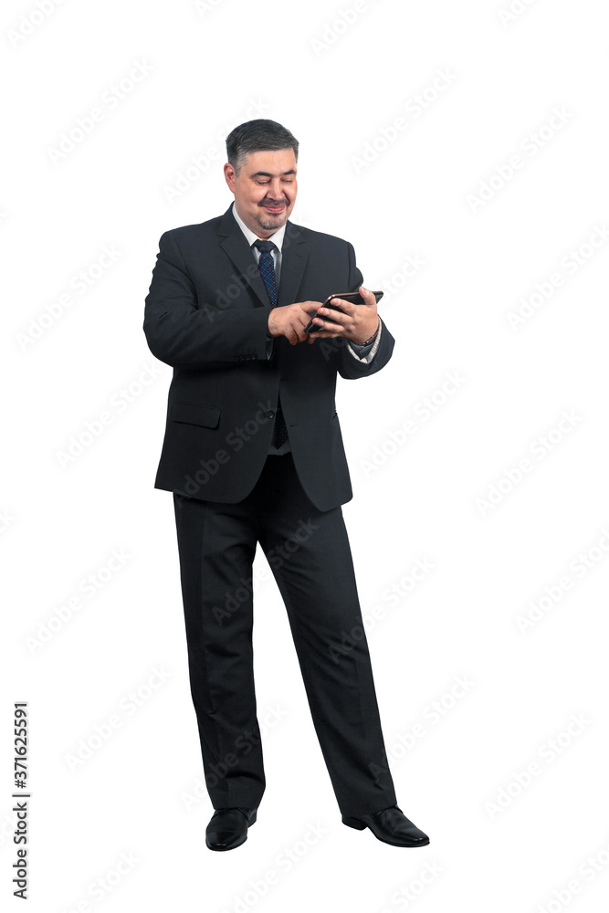 A man businessman in a suit with a smile surfs the news on a tablet A man businessman in a suit with a smile surfs the news on a tablet