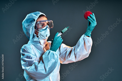 Medical doctor woman in protective suit fighting wigh Covid-19. Vaccine against coronavirus. photo