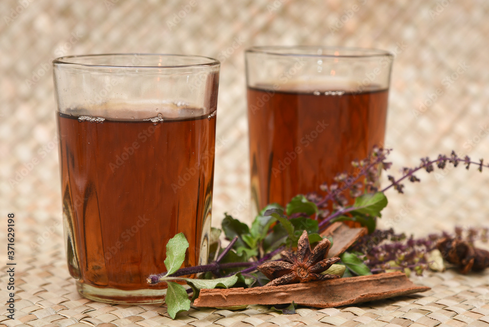 Indian Masala Chai black tea, traditional Tulsi herbal tea beverage with or without milk and spices Kerala India. Two cups organic ayurvedic herbal drink India, good in winter for immunity boosting. Indian Masala Chai black tea, traditional Tulsi herbal tea beverage with or without milk and spices Kerala India. Two cups organic ayurvedic herbal drink India, good in winter for immunity boosting.