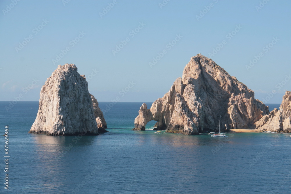 rocks in bay of cabo san lucas blue sky and blue water