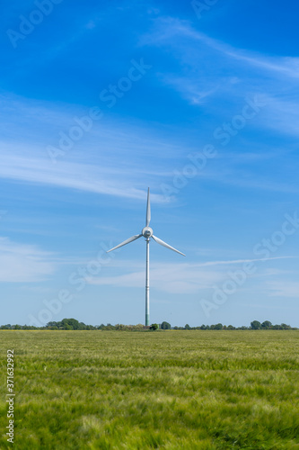 A symbol for green energy, wind turbine on a green field at Fehmarn in Schleswig Holstein Germany.