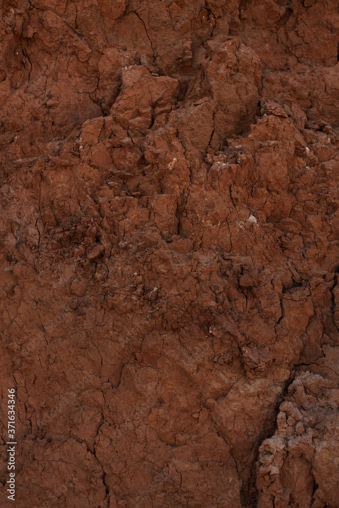 Textured background - relief dry cracked brown earth. Uneven crack rock