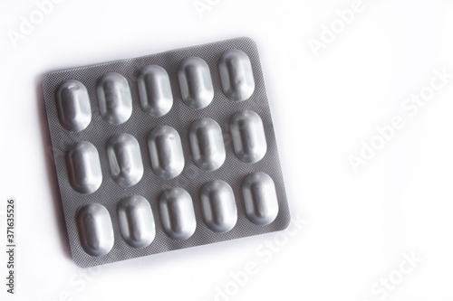 Pills in silver packaging on white background..