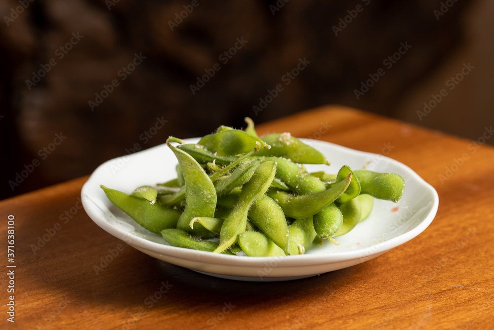 Edamame Nibbles, boiled green soybeans on a plate, Japanese food. Edamame Nibbles, boiled green soybeans on a plate, Japanese food.