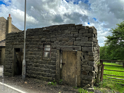 Ruins of an old stone building, next to a farm gate, with a field to one side near, Steeton, Keighley, UK  photo