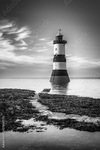 lighthouse on the shore black and white  photo