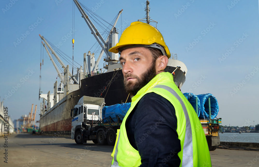 Engineer standing against container ship and truck at over seaport. Engineer standing against container ship and truck at over seaport.