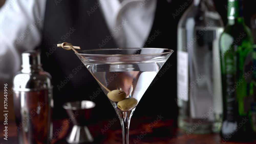 bartender serving martini in glass at bar